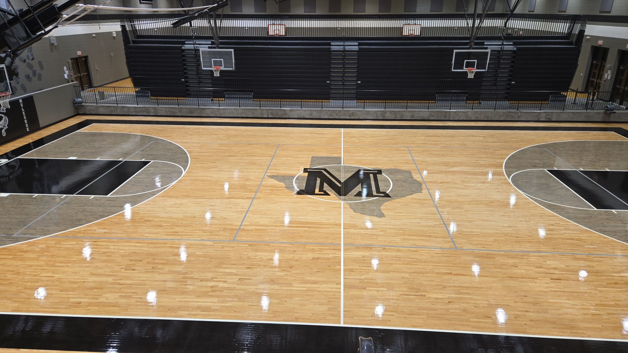 Full indoor basketball court with custom floor graphics and basketball hoops